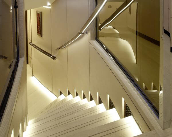 Beleuchtete Treppe aus hochwertigen Oberflächen an Bord einer Luxus-Segelyacht – bsw yachteinrichter